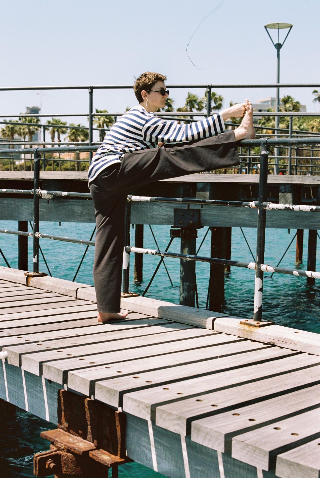 Standing leg stretch at the pier railing